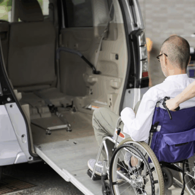 Man in wheelchair facing an empty van with a ramp.